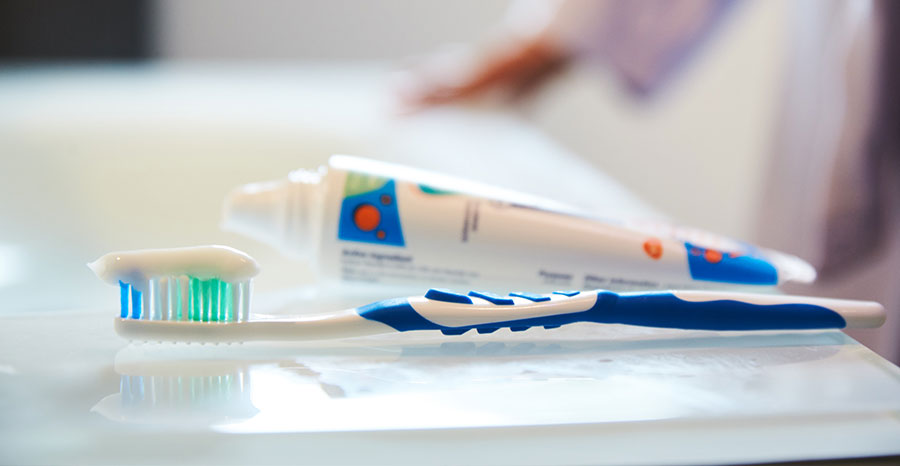 Tooth brush and paste laid on the table