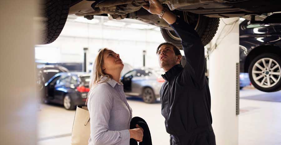 Mechanic showing a issue to a car owner